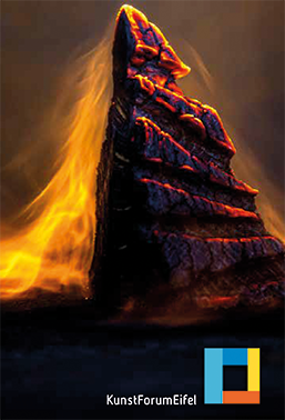 Ein beeindruckender Felsen, der von orangefarbenem Licht umgeben ist. Die Szenerie wirkt mystisch und dramatisch.