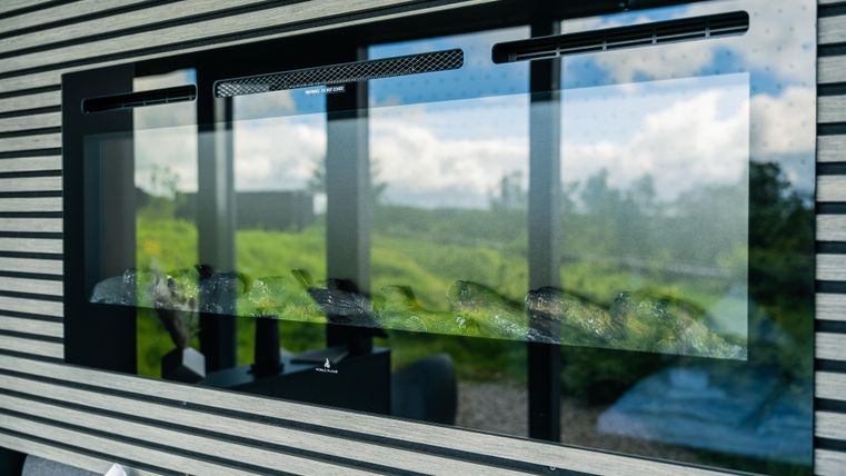 Ein modernes Glasdesign mit einem klaren Blick auf die Natur im Hintergrund. Die Wände sind mit horizontalen Streifen dekoriert, die dem Raum einen modernen Touch verleihen.