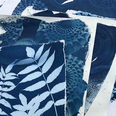 Ein Stapel blauer Papiere mit weißen Pflanzenmustern. Die Designs zeigen verschiedene florale und geometrische Motive.