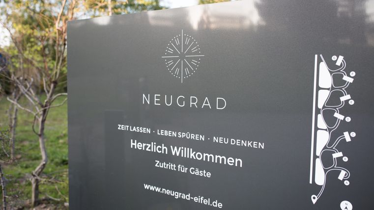 Ein Willkommen-Schild von Neugrad mit einladendem Design. Es enthält Informationen über den Zutritt für Gäste und die Website.
