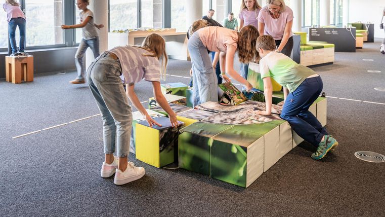 <p>Mehrere Besuchende, verschiedener Altersgruppen, betrachten unterschiedliche Ausstellungsstücke.</p>